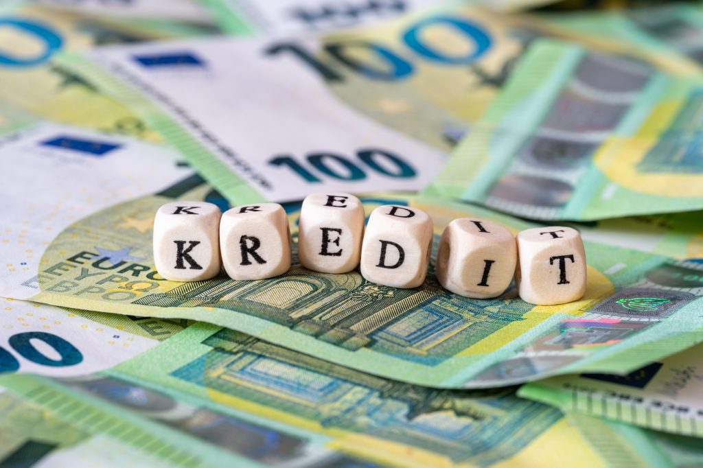 Closeup shot of the word kredit on wooden blocks on the stack of euro banknotes